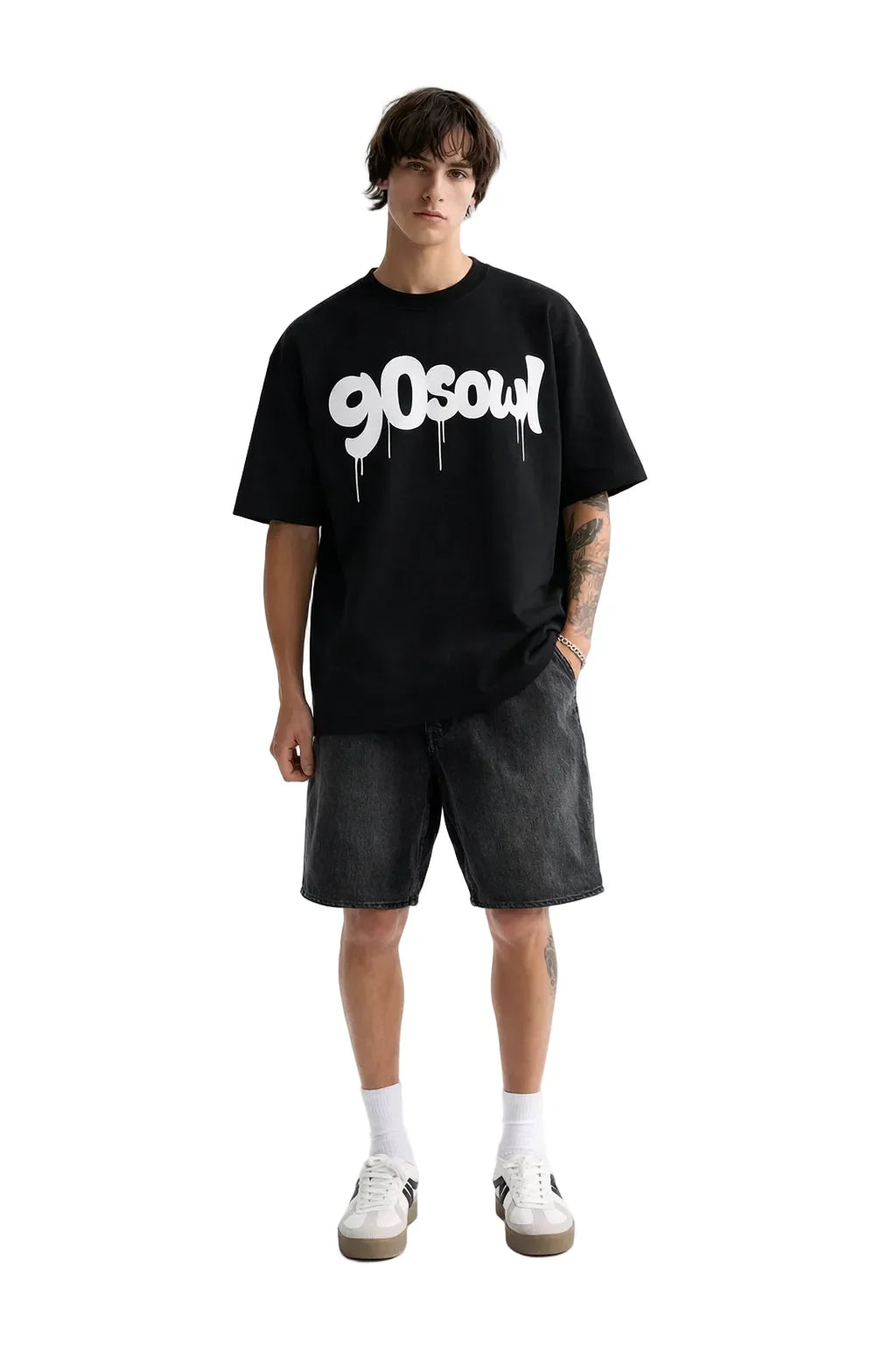 Man wearing oversized black t-shirt with graffiti 90s graphic, black denim shorts, and sneakers